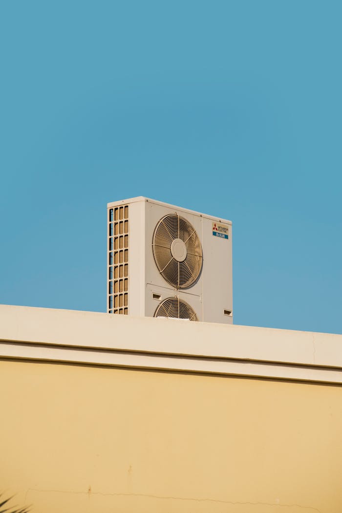 services-01 A simple and modern air conditioner unit on a rooftop with a blue sky backdrop in Dubai.