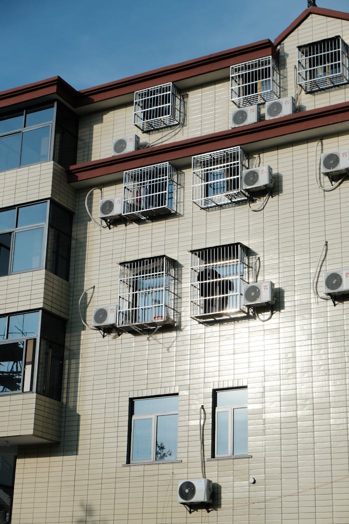 services-03 Exterior of a building with multiple air conditioners and window cages.
