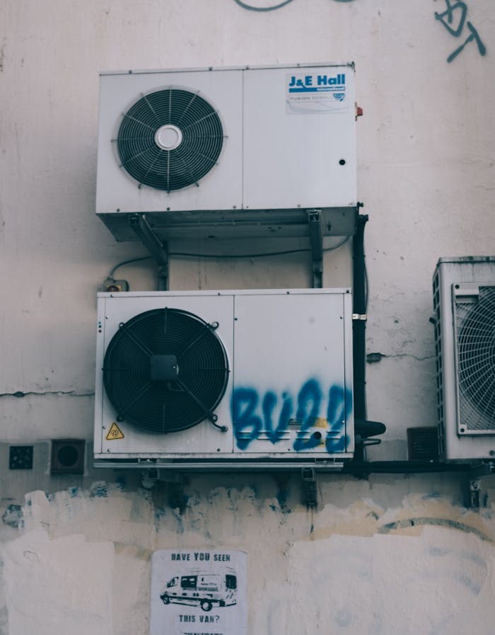 services-04 Low angle of weathered dirty air conditioner boxes installed on shabby wall of building on street