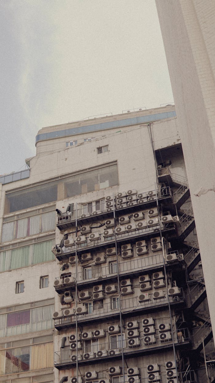 who-we-are A highrise building with prominent exterior air conditioning units viewed from a low angle.